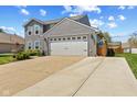 Two-story home with a two-car garage and a spacious driveway, complemented by a well-maintained lawn at 272 Van Buren St, Greenfield, IN 46140