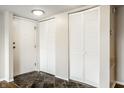 Inviting entryway with white doors, including louvered closets, and dark tile flooring, creating a stylish and organized space at 3127 E 52Nd St # C, Indianapolis, IN 46205