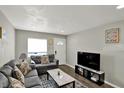 Bright living room featuring a comfortable gray sofa, modern decor, and dark wood flooring at 3538 Cecil Ave, Indianapolis, IN 46226