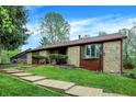 Charming stone home featuring a brown roof, well-maintained lawn, and wooden walkway leading to the entrance at 3875 Arrowhead Ct, Greenfield, IN 46140