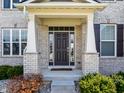 Charming front porch features a stylish door, decorative columns, and brick accents at 3997 Spylaw Rd, Bargersville, IN 46106