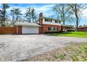Two story brick home with an attached garage and driveway at 4260 Springwood Trl, Indianapolis, IN 46228