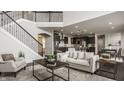 Bright and airy living room with a fireplace, staircase, and open floor plan at 4428 Voyageur Way, Carmel, IN 46074