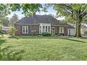 Quaint brick home featuring a manicured front lawn and welcoming entrance at 5747 Allisonville Rd, Indianapolis, IN 46220