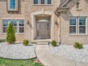 Charming front entrance with a pathway, decorative shrubbery, and stone accents at 6044 Shallow Crk Ln, Indianapolis, IN 46237