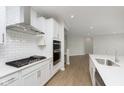 Modern kitchen with white cabinets, stainless steel appliances, and a subway tile backsplash at 6474 Ambassador Dr, Plainfield, IN 46168
