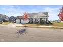 Charming one-story home with a three car garage, neutral siding, and a tree in the front yard at 7067 Hart St, Cumberland, IN 46229