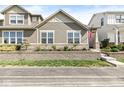 A well-maintained home with a stone retaining wall, landscaping, and a patriotic American flag at 7092 Cherry Creek Blvd, Carmel, IN 46033