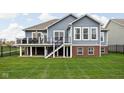 Rear exterior of home with a spacious deck, well-manicured lawn and stairs leading to the yard at 7450 Cassilly Ct, Indianapolis, IN 46278