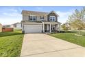 Inviting two-story home with a large driveway and manicured lawn and mature trees at 7901 Apalachee Dr, Indianapolis, IN 46217