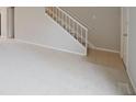 Open concept living area with plush carpeting and a staircase at 8116 Cheswick Dr, Indianapolis, IN 46219
