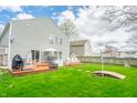 The expansive backyard features a deck, mature trees, and lush green grass, ideal for relaxation and entertainment at 853 Westpointe Dr, Shelbyville, IN 46176