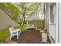 A cozy backyard nook features comfortable seating, mulched area and mature trees, providing a peaceful retreat at 853 Westpointe Dr, Shelbyville, IN 46176