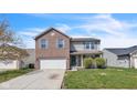 Charming two-story home featuring a brick and siding facade, attached two car garage, and a well manicured front lawn at 8888 N White Tail N Trl, McCordsville, IN 46055