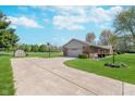 Long concrete driveway leading to a two-car garage with basketball hoop at 990 Broadway N Dr, Plainfield, IN 46168