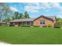 Beautiful brick ranch-style home with a lush green lawn and mature landscaping at 990 Broadway N Dr, Plainfield, IN 46168