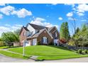 Well-maintained brick home on a corner lot with a lush green lawn and mature trees at 10715 Hamilton Pass, Fishers, IN 46037
