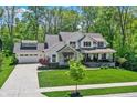Beautiful two-story home with attached garage and a well-manicured lawn surrounded by trees at 10725 Holliday Farms Blvd, Zionsville, IN 46077