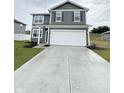 Inviting two-story home featuring gray siding and a spacious concrete driveway leading to the attached garage at 10931 N Longbranch St, Monrovia, IN 46157