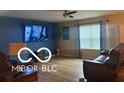 Comfortable living room featuring hardwood floors, media center, and bright window at 11555 Ross Common Dr, Indianapolis, IN 46229