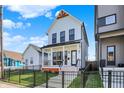 Charming two-story home with a black wrought iron fence, small porch, and well-manicured lawn at 1317 Spann Ave, Indianapolis, IN 46203