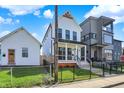 Charming two-story home with a black wrought iron fence, small porch, and well-manicured lawn at 1317 Spann Ave, Indianapolis, IN 46203