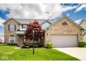 Beautiful two-story brick home with lush lawn, mature red maple, and an attached two-car garage, perfect for Gathering living at 13331 Grouse Point Trl, Carmel, IN 46033