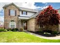 Inviting brick home with a well-maintained lawn, mature shrubs, and a covered front entryway offering classic curb appeal at 13331 Grouse Point Trl, Carmel, IN 46033