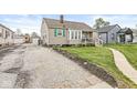 Charming home with front yard, driveway, and green shutters in a quiet neighborhood at 1412 Wallace Ave, Indianapolis, IN 46201
