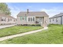 Single-story home with manicured front lawn, pathway, and charming curb appeal in a quiet neighborhood at 1412 Wallace Ave, Indianapolis, IN 46201
