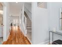Hallway leading to the living room and featuring wood floors and carpeted stairs at 1453 English Ave, Indianapolis, IN 46201