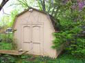 Back of storage shed in wooded backyard features colorful vegetation at 14544 Lynn Ave, Fishers, IN 46038