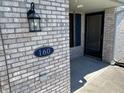 Close-up of the front door and brick facade featuring house number and covered entryway at 160 Bay Ridge Dr, Pendleton, IN 46064