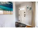 Welcoming entryway with slate tile flooring, white door, and calming wall decor at 1733 N Spencer Ave, Indianapolis, IN 46218