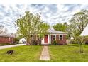 Quaint brick home with green grass and a walkway leading up to the front door at 1733 N Spencer Ave, Indianapolis, IN 46218