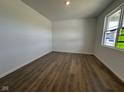 A bedroom with wood flooring, white walls, and a window allowing ample natural light at 196 Aster Way, Greenfield, IN 46140