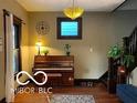 Inviting entryway showcasing a piano, warm lighting, and hardwood floors at 2001 Hoyt Ave, Indianapolis, IN 46203
