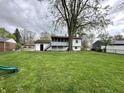 Spacious backyard with lush green grass, a large shade tree, and a charming patio area at 210 Prairie Pkwy, Brownsburg, IN 46112