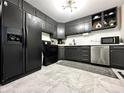 Modern kitchen with sleek black cabinets, stainless steel appliances, and stylish countertops at 210 Prairie Pkwy, Brownsburg, IN 46112