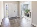 Bright foyer with hardwood floors, coat rack, and glass door leading to the study at 2168 Hengist Dr, Westfield, IN 46074