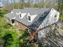 An aerial view shows the brick home, gray roof, attached garage, and surrounding lush greenery at 2394 W 600 S, New Palestine, IN 46163
