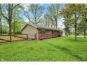 Backyard of this well-maintained home showcasing a lush lawn, wooden fence, and a combination of vinyl and brick siding at 2920 N Buck Creek Rd, Greenfield, IN 46140