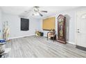 An open living room featuring gray-toned flooring, a ceiling fan, and two windows at 306 W Clyde St, Frankton, IN 46044