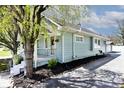 Well-maintained house with light blue siding, landscaped garden, and mature tree at 316 S Arlington Ave, Indianapolis, IN 46219