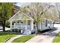 Attractive home with light blue siding, a welcoming front porch, and mature trees at 316 S Arlington Ave, Indianapolis, IN 46219