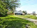 Landscaped front yard with mature trees and a charming home in the background at 3514 Carson Ave, Indianapolis, IN 46227