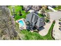 A large home aerial view with a pool, surrounded by a lush green lawn with outdoor furniture at 3940 Woodcrest Ct, Westfield, IN 46062