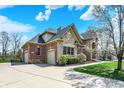 Brick and stone house featuring a three-car garage, well-manicured landscaping, and mature trees at 3940 Woodcrest Ct, Westfield, IN 46062