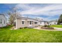 Small home with a green lawn and inviting landscaping, showcasing a tidy exterior at 4203 Main St, Anderson, IN 46013
