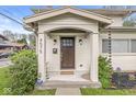Close-up of front door with decorated porch, plants, and rain chains at 4575 N Guilford Ave, Indianapolis, IN 46205